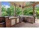 Covered outdoor kitchen with stainless steel appliances and brick surround at 4105 Cougar Ne Pt, Marietta, GA 30066