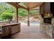 Covered outdoor kitchen with stone fireplace overlooking the pool at 4105 Cougar Ne Pt, Marietta, GA 30066