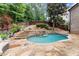Backyard pool with stone waterfall feature and adjacent landscaping at 4105 Cougar Ne Pt, Marietta, GA 30066