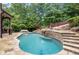 Backyard pool and stone waterfall, surrounded by lush greenery at 4105 Cougar Ne Pt, Marietta, GA 30066