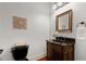 Traditional powder room with a black toilet and ornate vanity with granite countertop and framed mirror at 4105 Cougar Ne Pt, Marietta, GA 30066