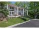 Elegant white home with grand columns, complemented by lush landscaping and a welcoming entrance at 1011 W Paces Ferry Nw Rd, Atlanta, GA 30327