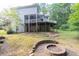 This backyard has tiered landscaping with a brick fire pit, large trees, and access to the home's back patio at 1253 Rivermark Ct, Lawrenceville, GA 30043