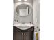 Elegant bathroom featuring a stylish oval mirror, a sleek vanity, and modern fixtures at 1253 Rivermark Ct, Lawrenceville, GA 30043