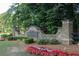 Picturesque stone entrance to Rivershyne community with colorful flowerbeds at 1253 Rivermark Ct, Lawrenceville, GA 30043