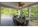 The covered deck offers outdoor dining with a fan, grill, and a view of the serene, tree-lined backyard at 1253 Rivermark Ct, Lawrenceville, GA 30043