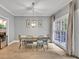 A cozy dining room with a modern chandelier, natural light from the backyard, and neutral paint colors at 1253 Rivermark Ct, Lawrenceville, GA 30043