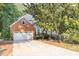 A traditional brick home featuring an attached two-car garage, driveway and mature trees at 1253 Rivermark Ct, Lawrenceville, GA 30043