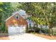 A traditional brick home featuring an attached two-car garage and mature trees at 1253 Rivermark Ct, Lawrenceville, GA 30043