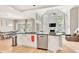 Open floor plan of the kitchen with stainless steel appliances, granite countertop island, and adjacent living space at 1253 Rivermark Ct, Lawrenceville, GA 30043