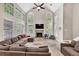 Bright living room featuring a vaulted ceiling, large windows, fireplace, and a comfortable oversized sectional sofa at 1253 Rivermark Ct, Lawrenceville, GA 30043