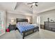 Comfortable bedroom featuring a ceiling fan, tray ceiling and a dresser at 1253 Rivermark Ct, Lawrenceville, GA 30043
