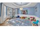 Spacious playroom featuring blue walls with white trim, decorative ceiling and a large patterned rug at 1253 Rivermark Ct, Lawrenceville, GA 30043
