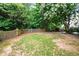 Picture of a large backyard enclosed by a wooden fence and surrounded by lush trees at 186 Wallnut Hall Cir, Woodstock, GA 30189