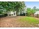View of the backyard with mature trees, wooden fence, and sliding glass door to the home at 186 Wallnut Hall Cir, Woodstock, GA 30189