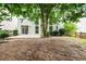 Back of home features large windows, trees, and a small patio at 186 Wallnut Hall Cir, Woodstock, GA 30189