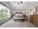 Inviting bedroom with a large window, neutral carpet, and a ceiling fan at 186 Wallnut Hall Cir, Woodstock, GA 30189