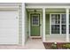 A close-up of the home's entrance, with a green door, white trim, and manicured landscaping at 186 Wallnut Hall Cir, Woodstock, GA 30189