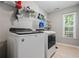 Well-equipped laundry room with a washer, dryer, storage shelves, and natural light at 186 Wallnut Hall Cir, Woodstock, GA 30189