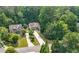 Aerial view of a suburban home with a long driveway and mature trees, nestled in a lush, green neighborhood at 2740 Creekside Manor Dr, Powder Springs, GA 30127