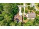 Aerial view of the house and backyard, featuring a long driveway, blue umbrella, and mature trees surrounding the property at 2740 Creekside Manor Dr, Powder Springs, GA 30127