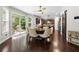 Sunlit dining area with a large window, dark floors, stylish lighting, and easy access to the backyard at 2740 Creekside Manor Dr, Powder Springs, GA 30127