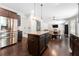 Open-concept kitchen features dark cabinets, stainless steel appliances, and a central island with pendant lighting at 2740 Creekside Manor Dr, Powder Springs, GA 30127