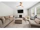 Comfortable living room with a fireplace, ceiling fan, neutral color palette, and ample seating at 2740 Creekside Manor Dr, Powder Springs, GA 30127