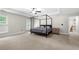 Large main bedroom featuring a canopy bed, neutral carpeting, and an abundance of natural light at 2740 Creekside Manor Dr, Powder Springs, GA 30127