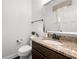 Elegant powder room featuring granite countertops and dark wood cabinets at 2740 Creekside Manor Dr, Powder Springs, GA 30127