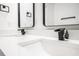 Well-lit dual-sink bathroom vanity features black fixtures, white countertop and decorative mirrors at 904 Fairburn Nw Pl, Atlanta, GA 30331