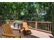 Charming back deck with wooden chairs surrounded by lush greenery and a decorative planter at 1251 Brickton Nw Dr, Atlanta, GA 30318