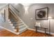 Foyer with staircase featuring hardwood floors and a decorative art piece on the wall at 1251 Brickton Nw Dr, Atlanta, GA 30318