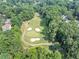 Scenic aerial shot of a well-manicured golf course with sand traps, surrounded by mature trees and greenery at 3535 Fairgreen Ct, Douglasville, GA 30135