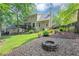 A fenced backyard features a stone firepit and lush greenery at 3535 Fairgreen Ct, Douglasville, GA 30135