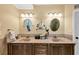 Bathroom featuring dual sinks, tan granite countertops, and updated mirrors at 3535 Fairgreen Ct, Douglasville, GA 30135