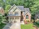 Beautiful two-story home with a well-kept lawn, brick accents, and a two-car garage, surrounded by mature trees at 3535 Fairgreen Ct, Douglasville, GA 30135