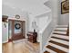 Inviting foyer featuring hardwood floors, a staircase, an antique console table, and a stylish glass-paneled front door at 3535 Fairgreen Ct, Douglasville, GA 30135