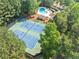 Aerial view of two well-maintained tennis courts and a community pool surrounded by lush greenery at 3535 Fairgreen Ct, Douglasville, GA 30135