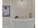 Modern bathroom with a freestanding tub, marble tile wall, and chandelier lighting at 750 Park Ne Ave # 6E, Atlanta, GA 30326