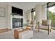 Cozy living room with a fireplace, comfortable seating, and large windows with elegant curtains at 750 Park Ne Ave # 6E, Atlanta, GA 30326