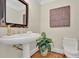 Well-appointed powder room with a pedestal sink, unique mirror, and decorative artwork for a polished look at 750 Park Ne Ave # 6E, Atlanta, GA 30326