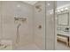 Walk-in shower with neutral tile and glass surround complemented by bathroom vanity in the background at 750 Park Ne Ave # 6E, Atlanta, GA 30326