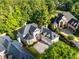 Aerial view showcasing the estate home's manicured lawn, stone driveway, and elegant architectural details at 8370 Royal Melbourne Way, Duluth, GA 30097