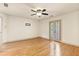 Roomy bedroom featuring hardwood floors and balcony access with shuttered doors at 8370 Royal Melbourne Way, Duluth, GA 30097
