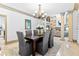 Dining room with chandelier and seating for six, adjacent to kitchen and living room at 8370 Royal Melbourne Way, Duluth, GA 30097
