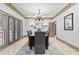 Dining room with chandelier, doors to the outside, and seating for six at 8370 Royal Melbourne Way, Duluth, GA 30097