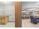 Open-concept living spaces boast travertine flooring and seamless flow between laundry, kitchen, and sitting area at 8370 Royal Melbourne Way, Duluth, GA 30097