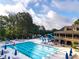 Community pool featuring lounge chairs, umbrellas, and a building with second story outdoor balconies at 8370 Royal Melbourne Way, Duluth, GA 30097