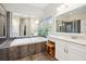 Luxurious bathroom with a large soaking tub, double vanity, and separate glass shower at 11259 Calypso Dr, Alpharetta, GA 30009